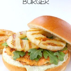 A Salmon Burger with pineapple on top and sauce dripping