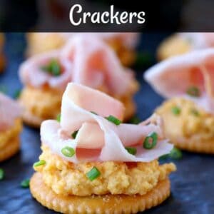 Cheese and cracker topped with a slice of ham