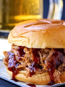 pulled pork sandwich with beer in background