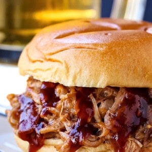 pulled pork sandwich with beer in background