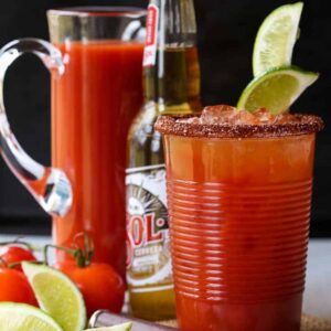 Michelada cocktail with a beer and a pitcher in the background