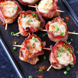 bacon wrapped scallops on black serving platter