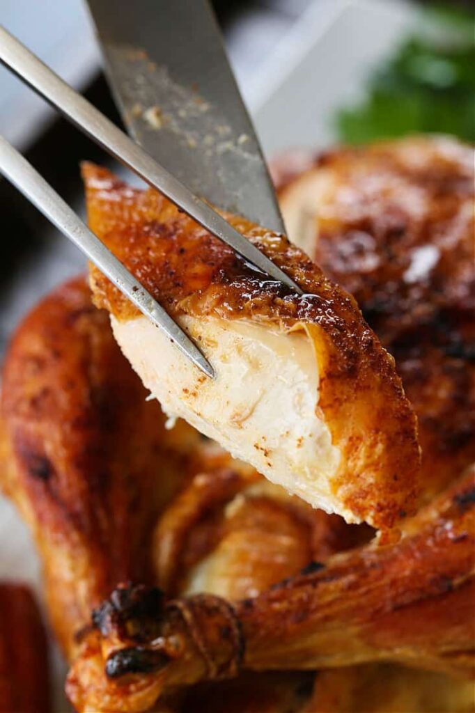 Slice of roast chicken on a serving fork