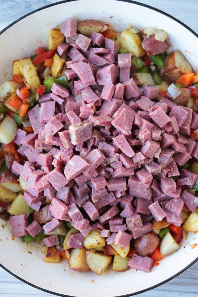 diced corned beef in a skillet with ingredients for making hash