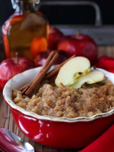 Homemade applesauce in a dish with cinnamon sticks