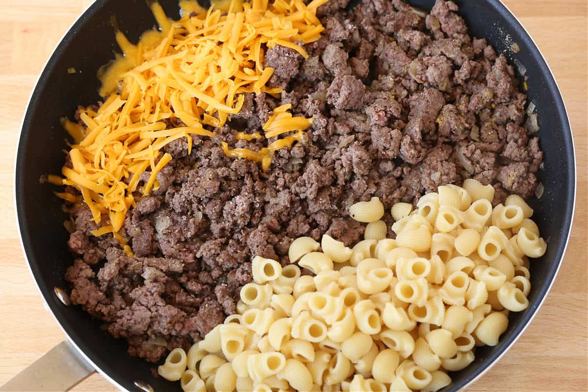 pasta, cooked ground beef and shredded cheese in a skillet