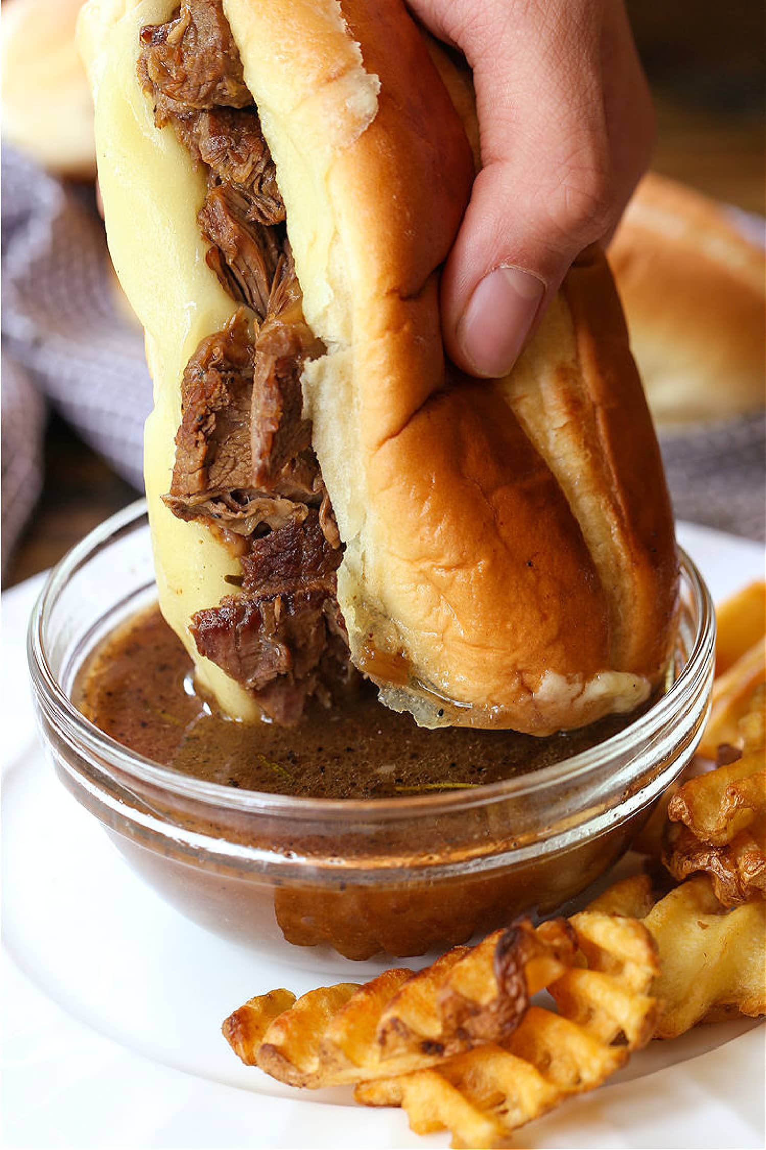 french dip sandwich dipping in au jus
