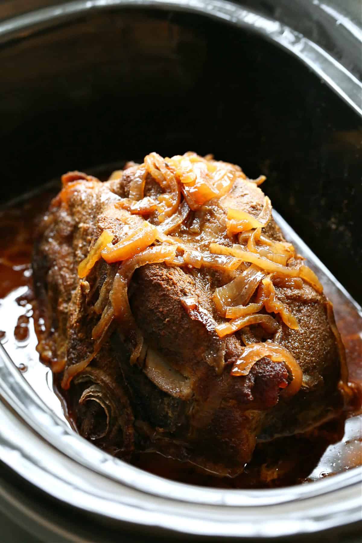 cooked pork butt with onions in crock pot