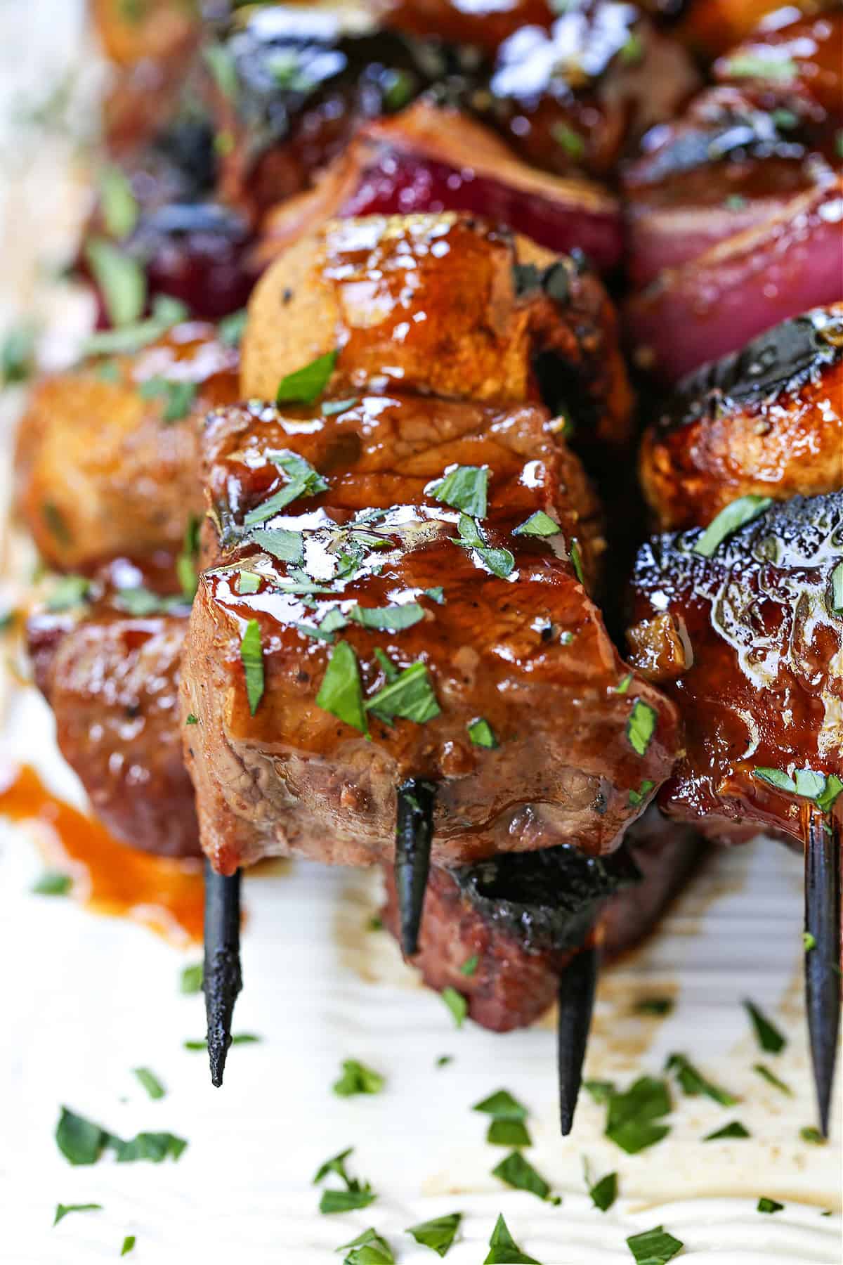 close up of steak kabob with chopped parsley