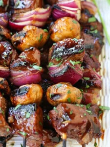steak and vegetable kabobs stacked on platter