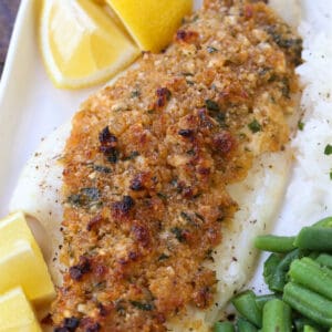 Parmesan Crusted Haddock on a plate with green beans and rice