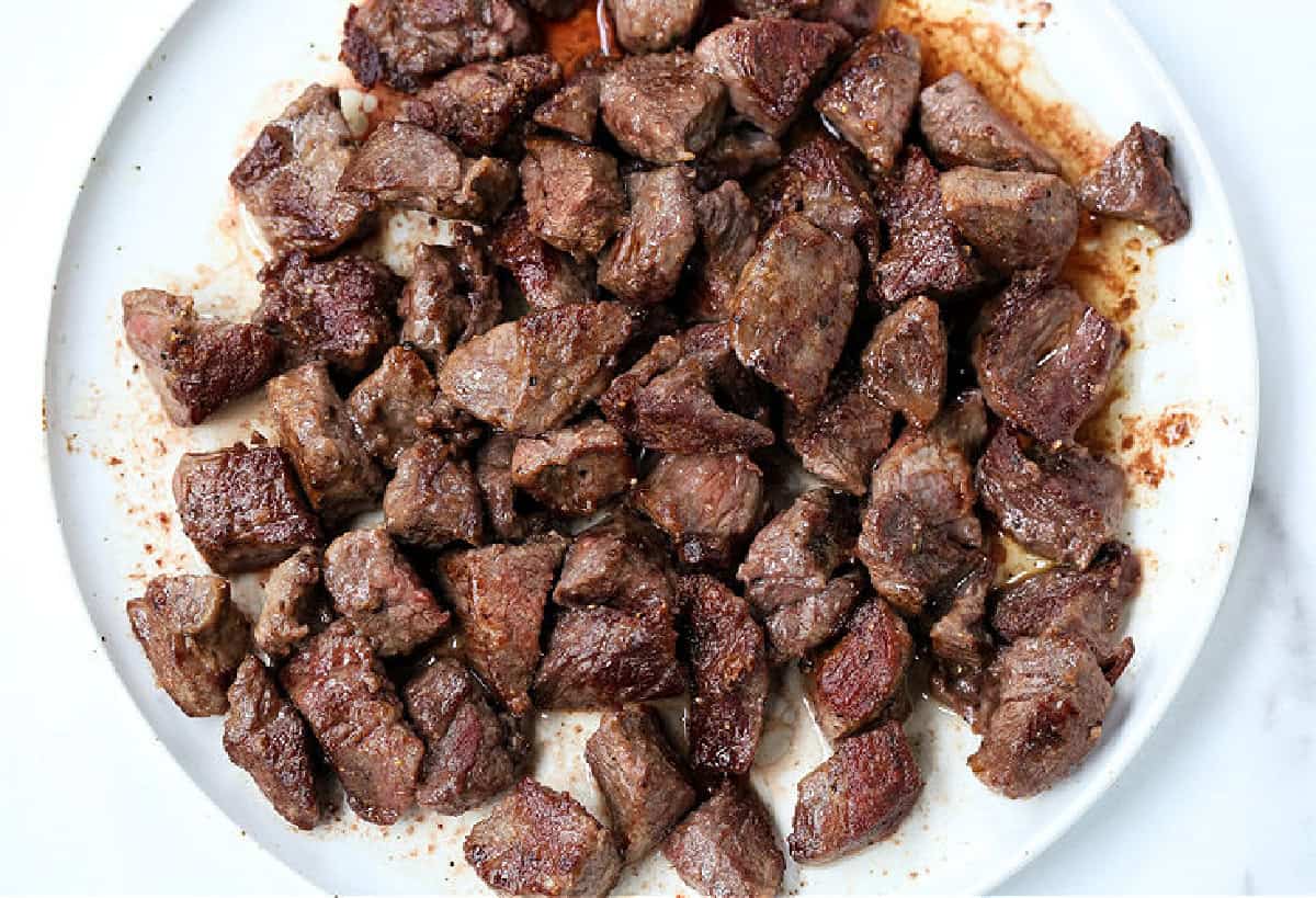 browned cubes of beef on white plate