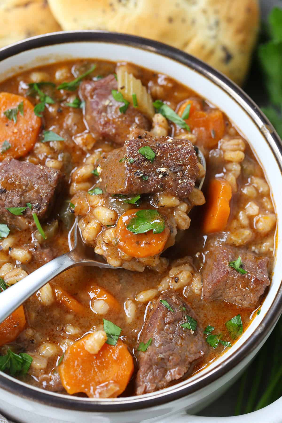 spoon in bowl of beef barley soup