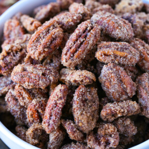 close up of candied pecans in a white bowl