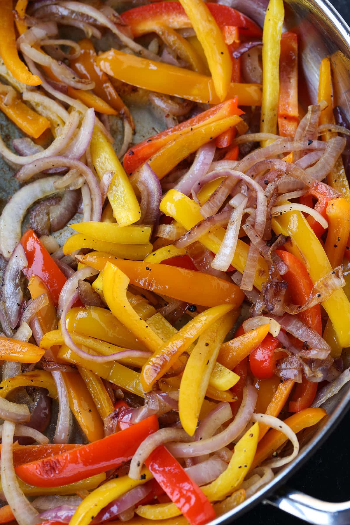 sliced peppers and onions in skillet for fajitas