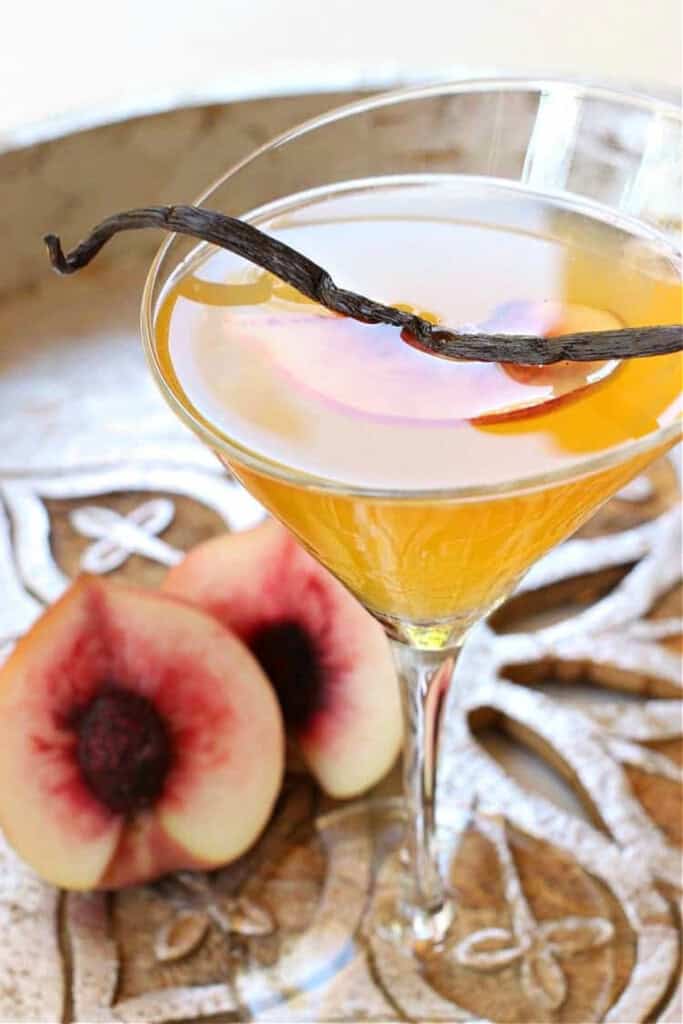 vanilla peach cosmopolitan cocktail with vanilla bean on top