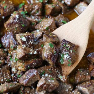 steak bites in garlic butter sauce with wooden spoon