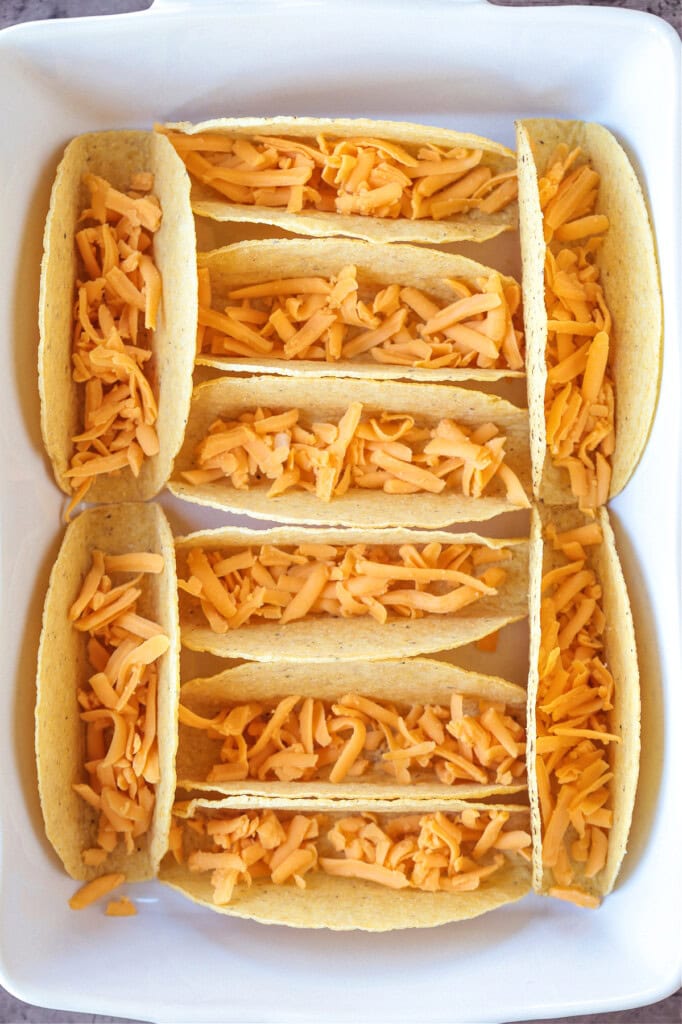 taco shells in baking dish with cheese