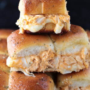 buffalo chicken sliders stacked on a sheet pan