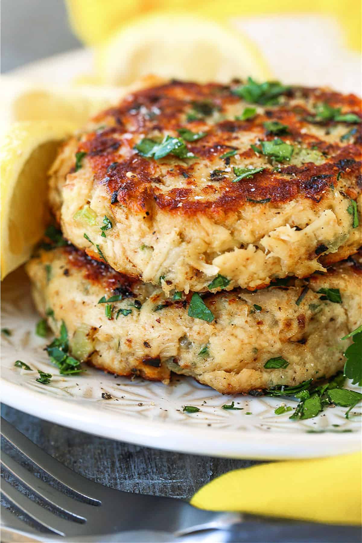 stacked tuna cakes on plate with yellow napkin