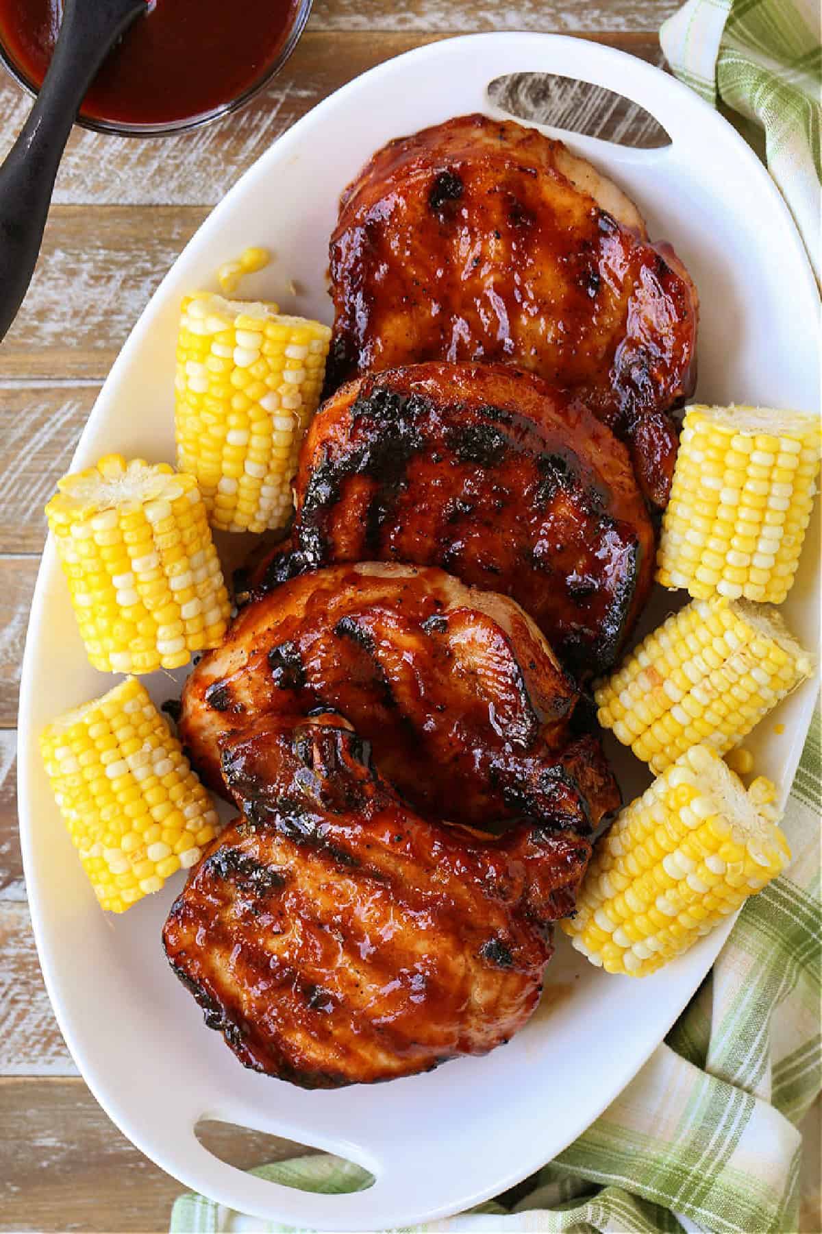 barbecue pork chops stacked on white platter