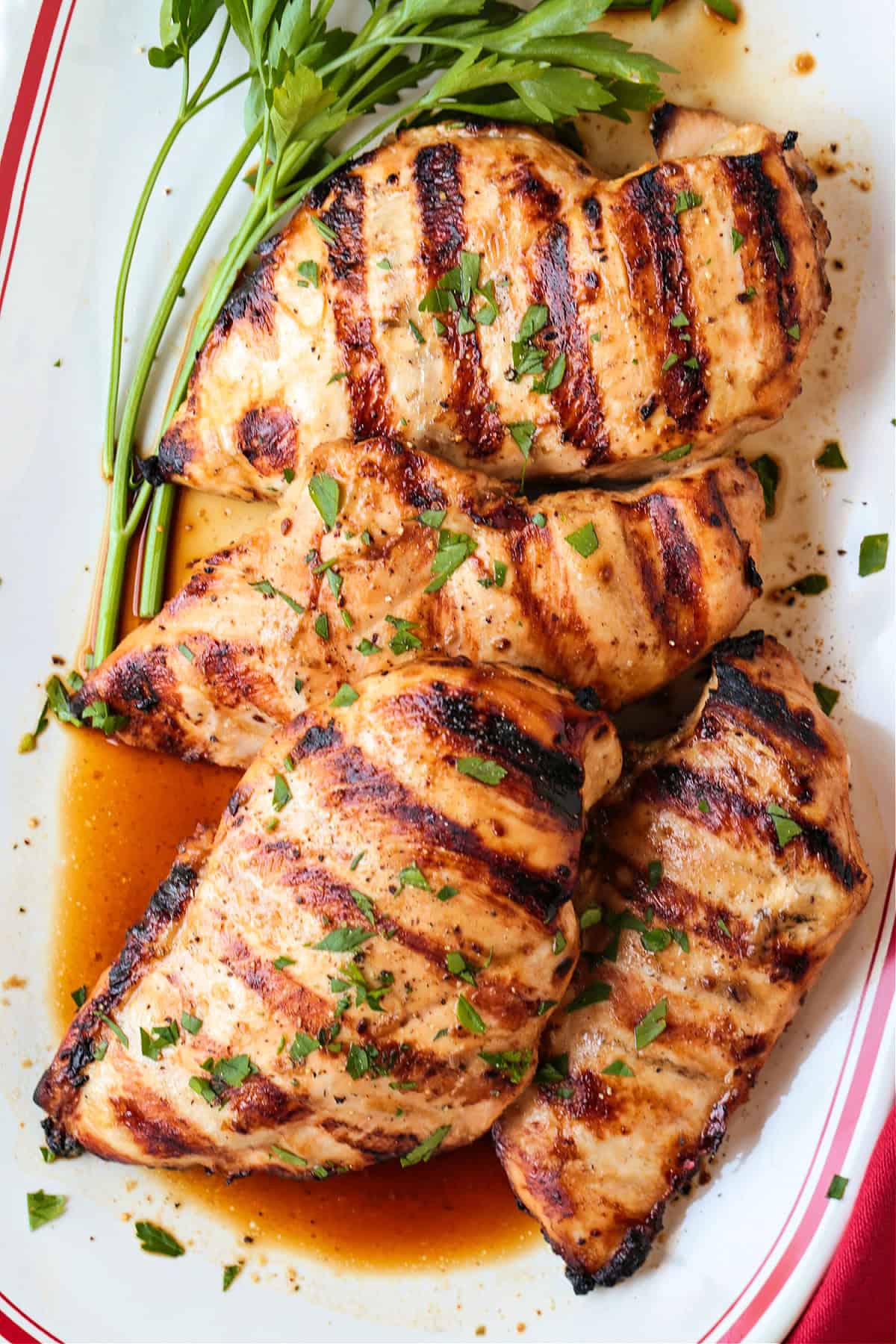 grilled chicken breasts on platter with parsley