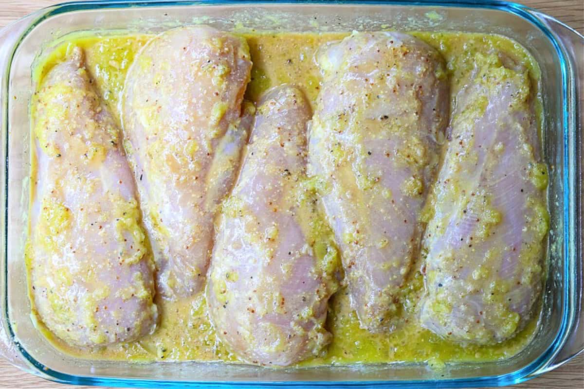 chicken breasts marinating in glass dish