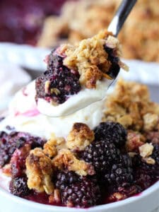 spoonful of berry crisp with vanilla ice cream