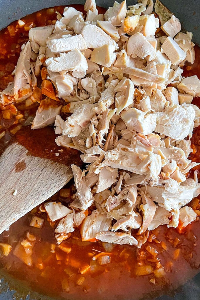 shredded chicken in skillet with sauce