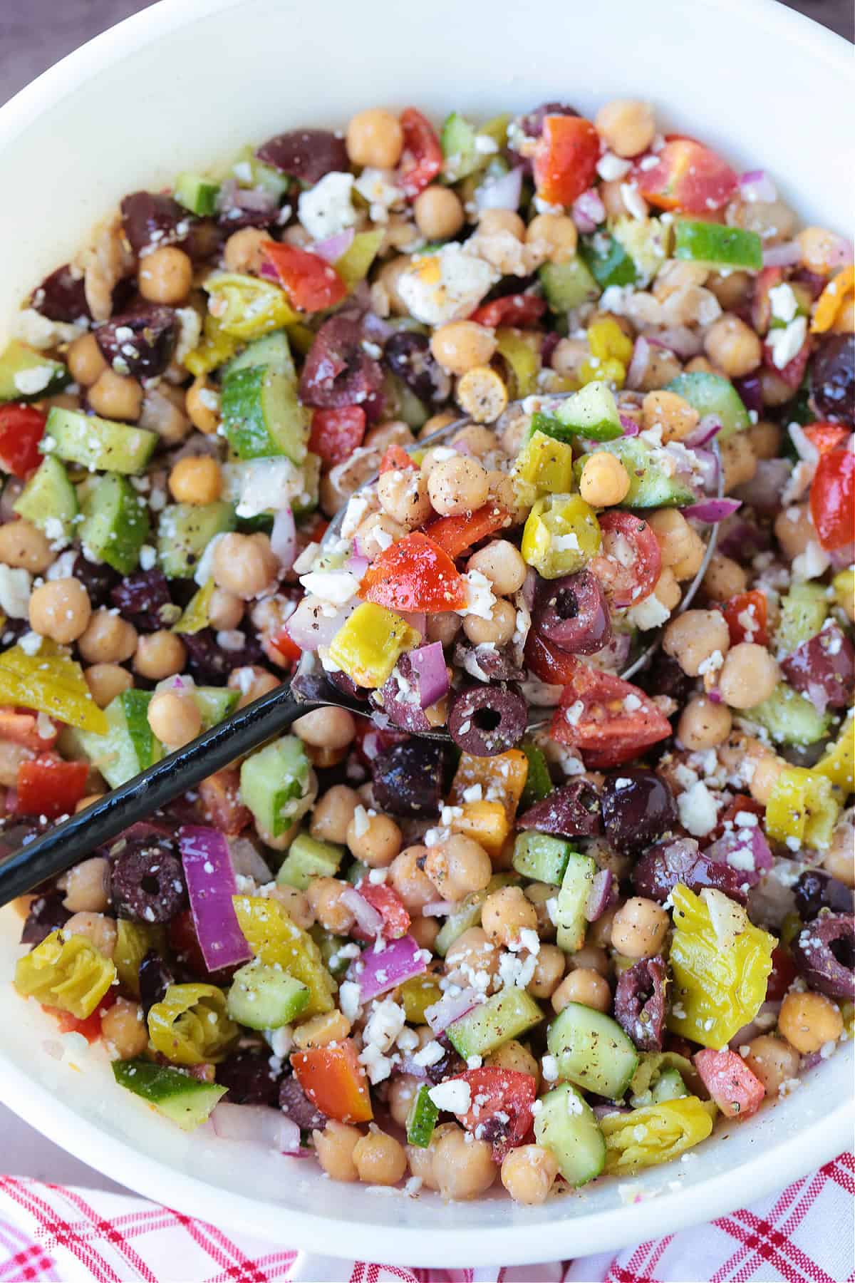 greek chickpea salad in a bowl with a spoon