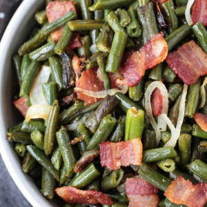 green beans in a bowl with bacon and onions