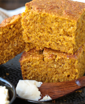 pumpkin cornbread stacked on a plate with a butter knife