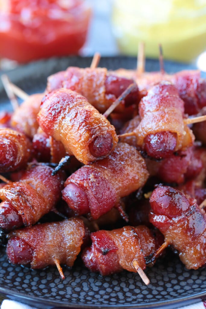 bacon wrapped smokies on plate with ketchup and mustard