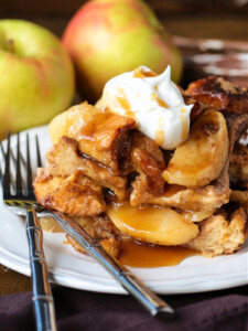 slice of apple bread pudding on plate with whipped cream