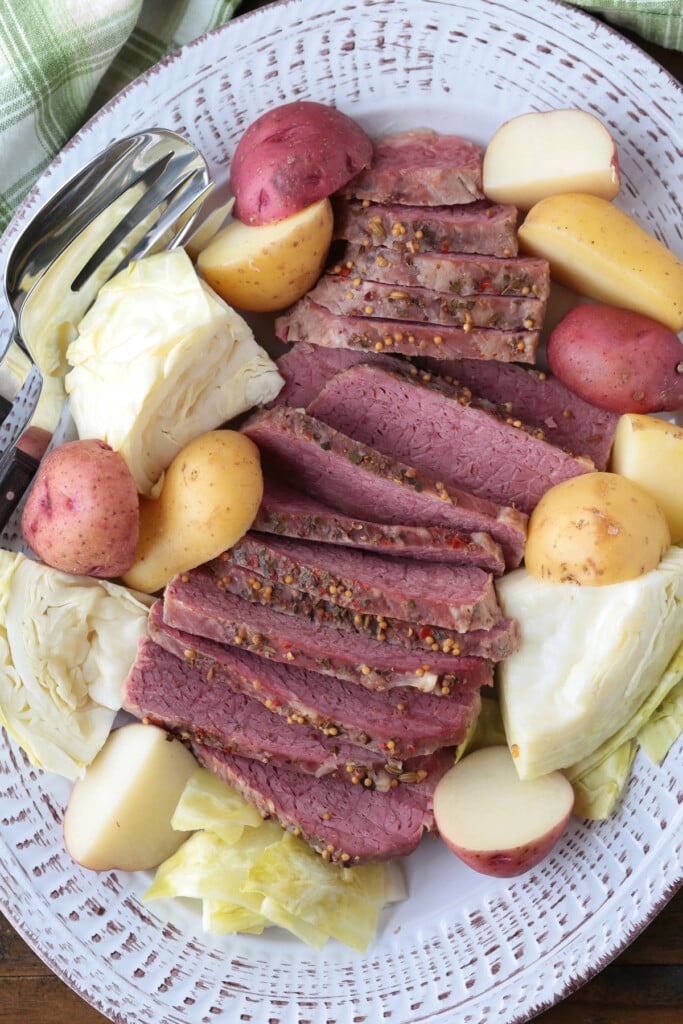 corned beef, cabbage and potatoes sliced on a white platter