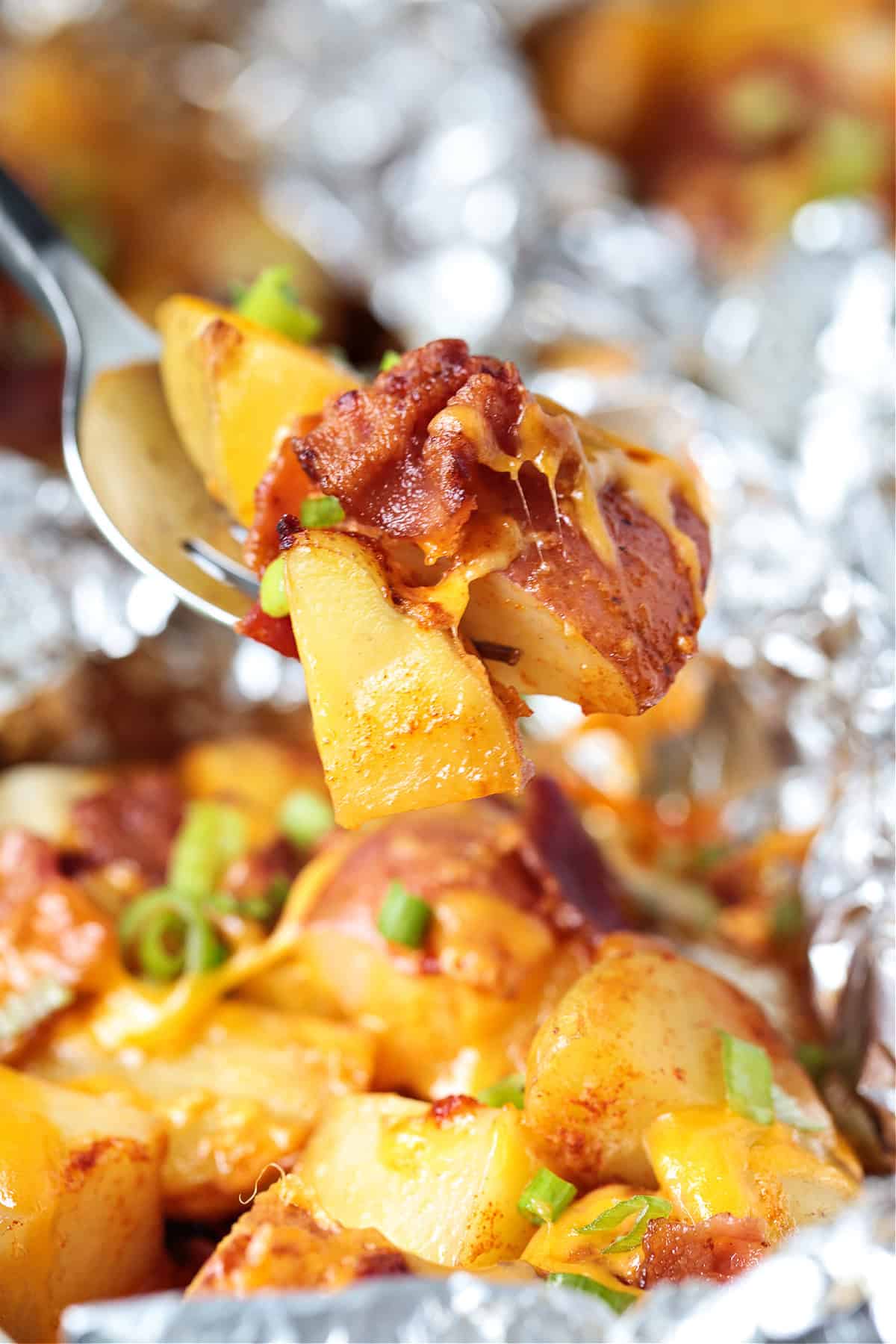 forkful of potatoes with bacon and cheese