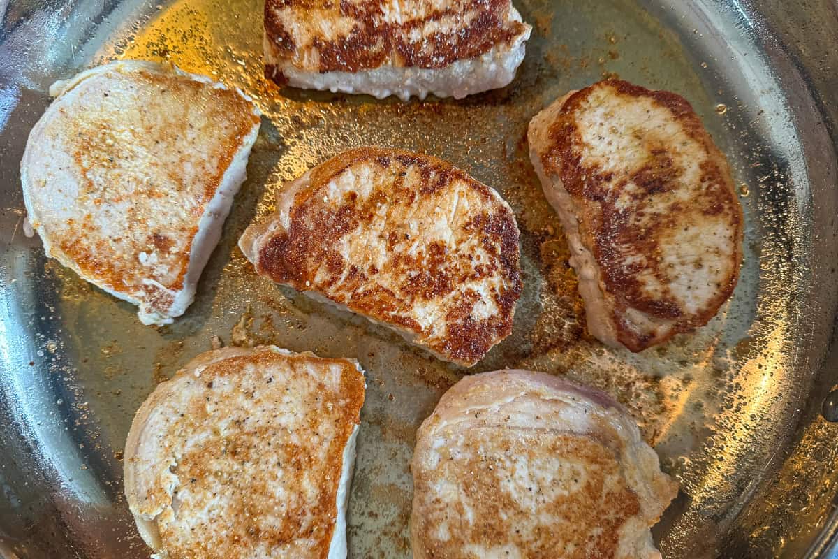 seared pork chops in a skillet