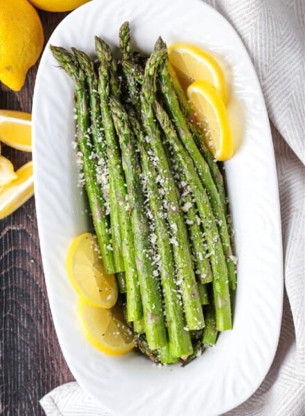 asparagus on white platter with lemon slices