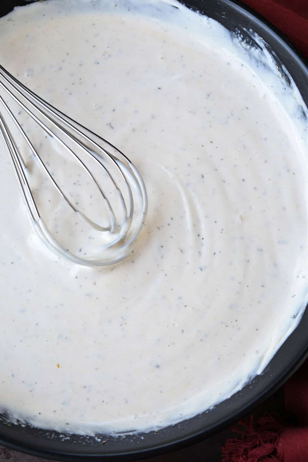 mayonnaise dressing for potato salad in bowl with whisk