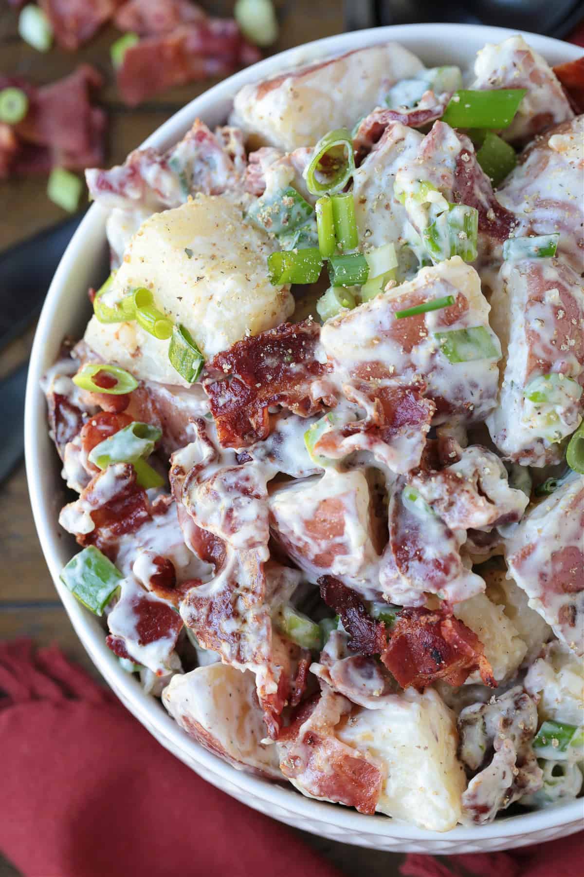 ranch potato salad in white bowl with napkin