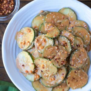 sliced cucumber salad in peanut sauce on plate