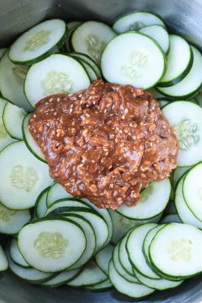 peanut sauce in bowl with sliced cucumbers