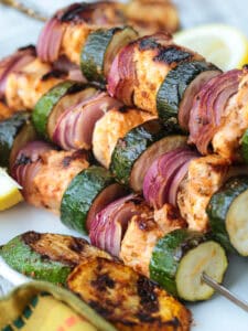 chicken kabobs with zucchini and red onion stacked on platter