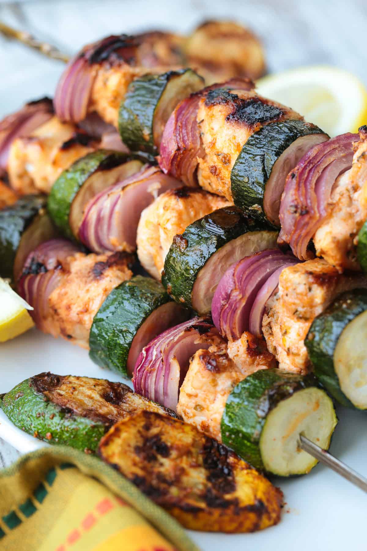 chicken kabobs with zucchini and red onion stacked on platter