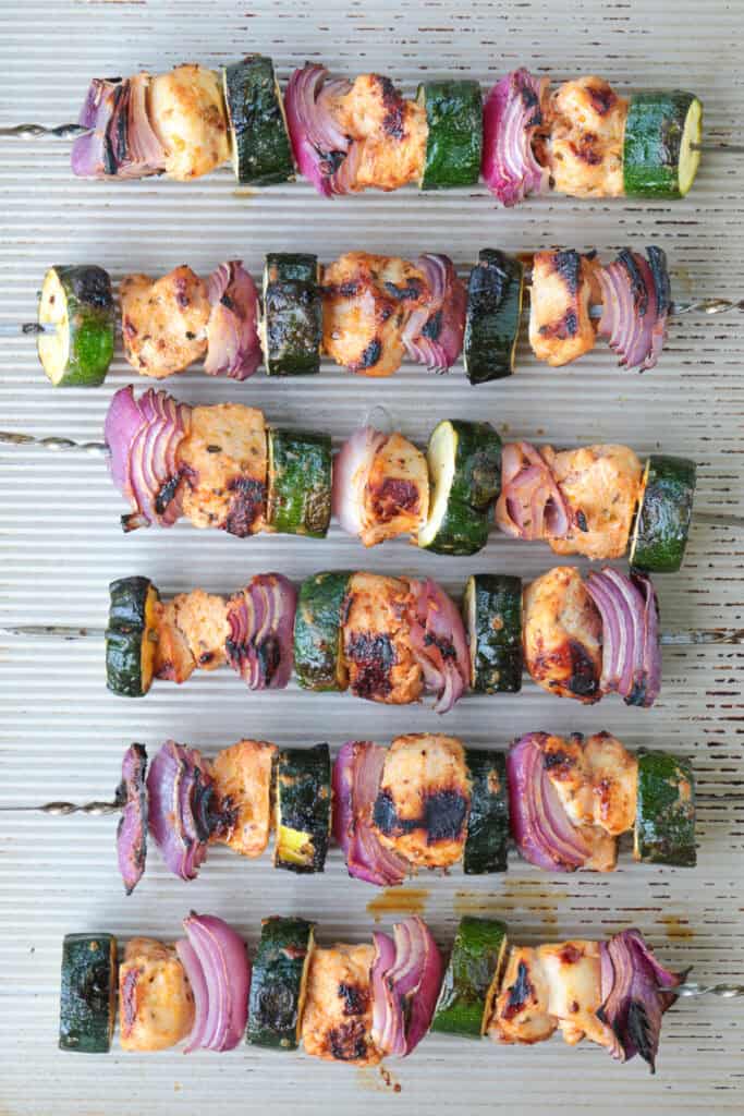 Chicken and vegetable kabobs on baking sheets