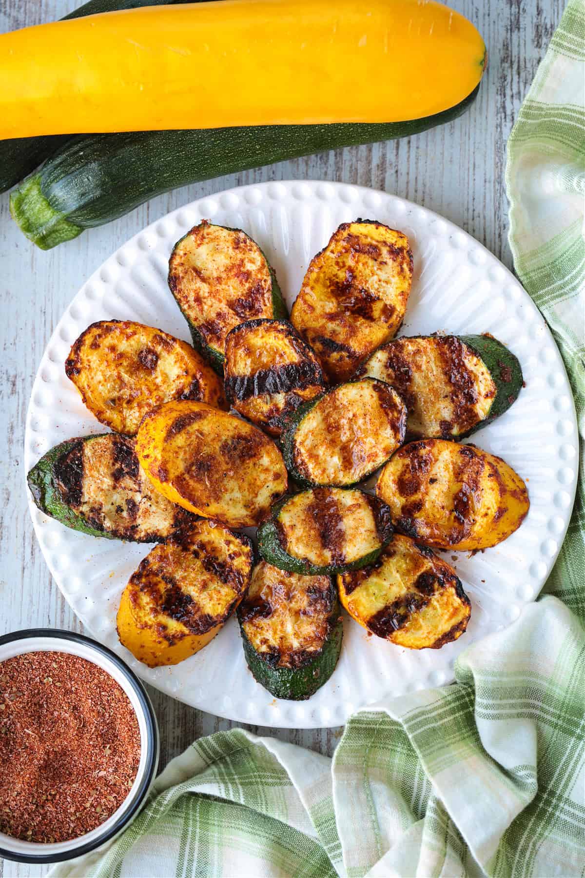 slices of grilled zucchini and squash layered on white plate