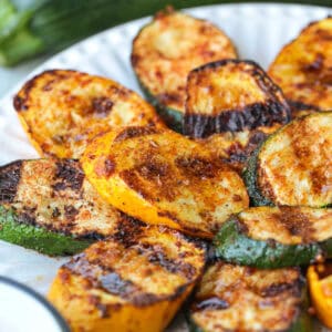 grilled slices of zucchini and squash stacked on plate