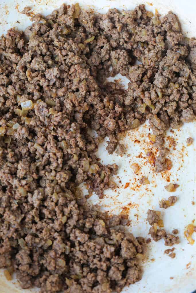 Cooked ground beef in a skillet with brown bits on the bottom