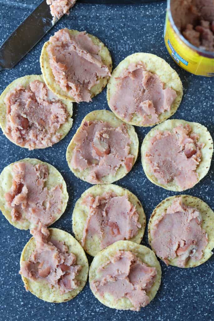 refried beans on round tortilla chips