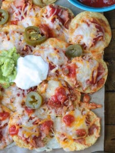 nachos with toppings on parchment paper